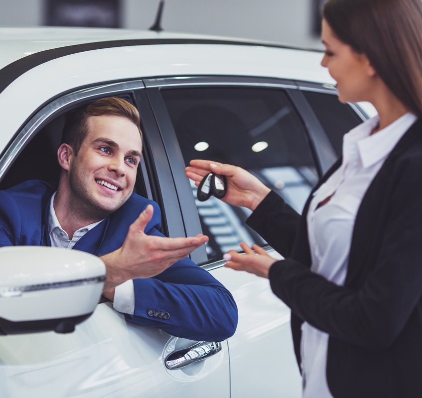 Hombre sonriente recibiendo llaves de auto